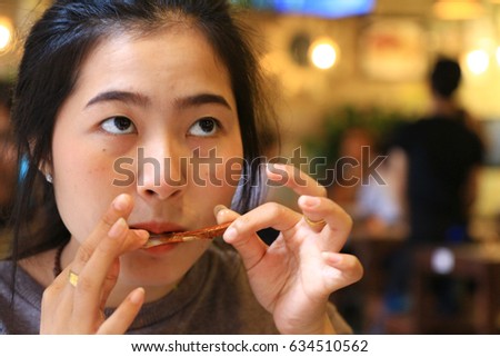 Girl in a somtum(Papaya salad) shop.With on the face shows a delicious spicy.