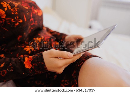 Blond woman using tablet at home in her bed.