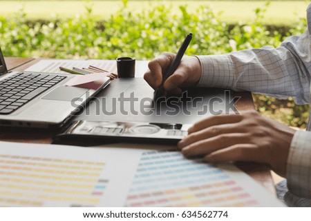 freelance artist graphic designer using digital tablet, computer, creative man working with color swatch palette catalog samples for selection - Creativity Editor Ideas Designer Concept