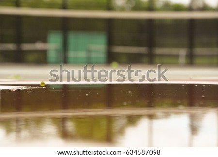Tennis court background. Empty space for text. Clear water reflection. Water puddle with droplets