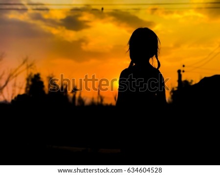 Silhouette of a girl watching sunset.