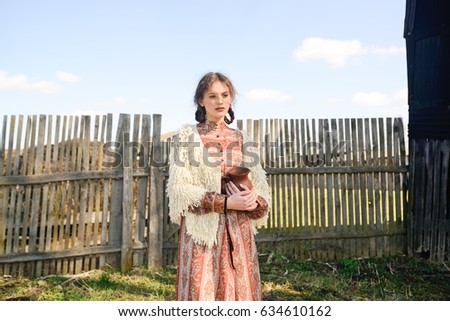 Beautiful young girl in a rustic style on nature in the countryside and in the woods with animals