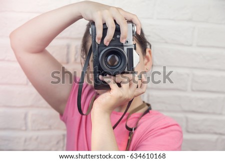 Young girl with an old photo camera