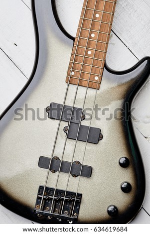 A bass guitar instrument isolated over white wooden background