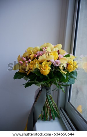 Fresh yellow bouquet of yellow roses and pink berries. Bright colors