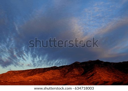 Red mountain sunset with huge clouds during monsoon season in Tucson, Arizona