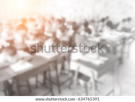 Blurred picture of student during study or exams in classroom in primary school.