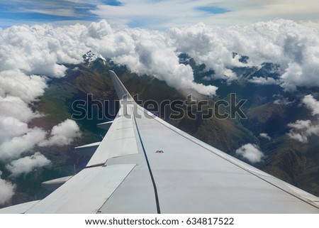 Airplane wing under mountain landscape of Andes. Traveling in South America