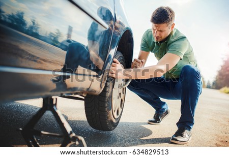 Man changing wheel after a car breakdown. Transportation, traveling concept Royalty-Free Stock Photo #634829513