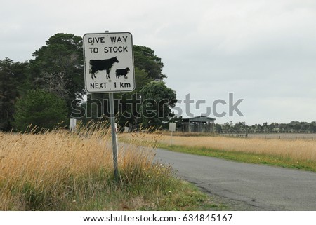 black and white Give Way to Stock sign in rural Australia