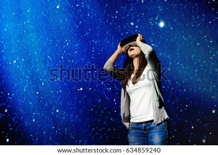 a beautiful girl wearing a virtual reality device, standing on the background of the sky