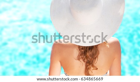 Woman wearing hat on the tropical beach. Summer holiday fashion concept
