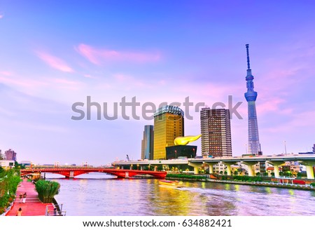 View of the Tokyo skyline along the river at dusk.