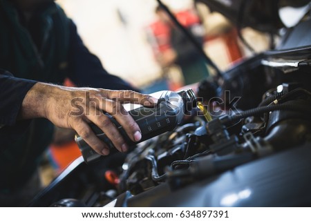 Close up hands of unrecognizable mechanic doing car service and maintenance. Oil and fuel filter changing. Royalty-Free Stock Photo #634897391
