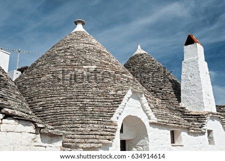Typical roofs of the Trulli houses under a blue sky in Alberobello, Puglia, Italy
