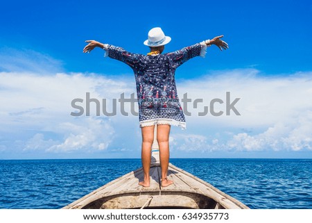 Traveler woman standing on wooden boat her arms open feeling freedom, Andaman sea, Mu Koh Surin national park, Phangnga, Thailand