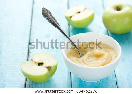Healthy organic applesauce (apple puree, mousse, baby food, sauce) in white bowl on table with green apples Royalty-Free Stock Photo #634962296