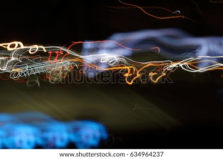 Slow speed shutter of abstract colorful light's motion in speeding car on dark blurred background.