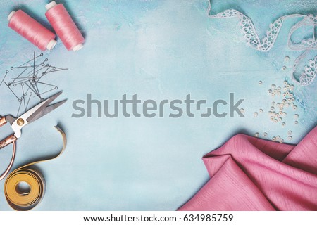 Tools for sewing: the fabric, scissors, pins, tape measure on blue concrete background (top view, flat lay) Royalty-Free Stock Photo #634985759