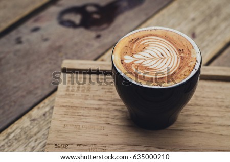 Love is Coffee on wooden background
