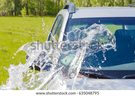Car rinsed with water on a grass background.