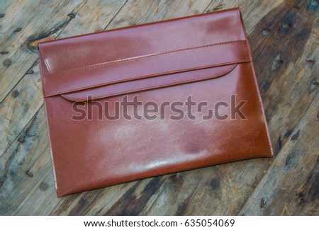 Brown leather business envelopes or Leather case put on wooden background.