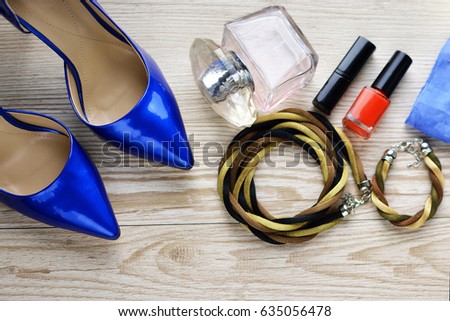 Jeans, shoes and perfume on the wooden background