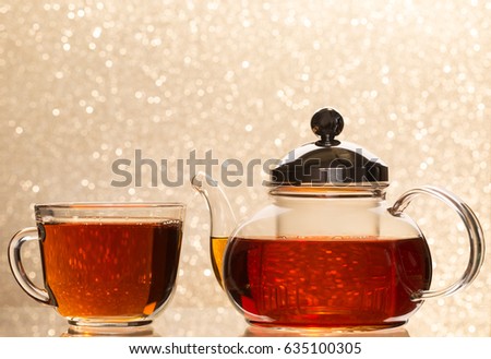 Tea pouring into glass cup and teapot