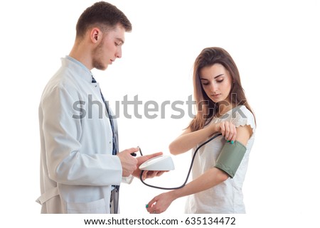 a young doctor in a white lab coat takes tanometrom pressure in female