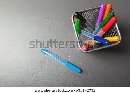 Colorful felt pens on the dark stone background top view
