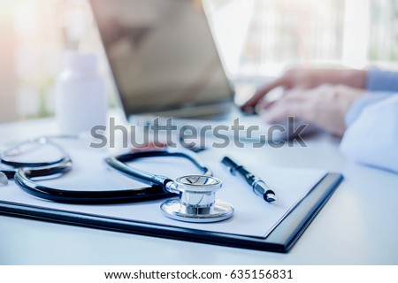 Stethoscope with clipboard and Laptop on desk Doctor working in hospital writing a prescription  Healthcare and medical concept test results in background vintage color selective focus.