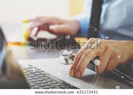 close up of smart medical doctor working with laptop computer and mobile phone and stethoscope on dark wooden desk with virtual reality icon diagram