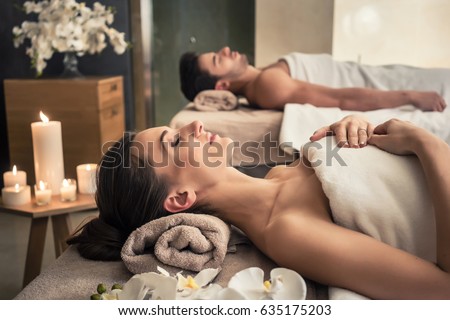 Young man and woman lying down on massage beds at Asian luxury spa and wellness center Royalty-Free Stock Photo #635175203