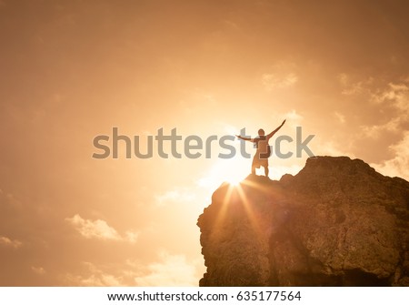 Success, life goals, fitness and achievement concept. Man standing on edge of mountain feeling victorious with arms up in the air. Royalty-Free Stock Photo #635177564
