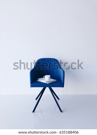 Blue chair with book on white background