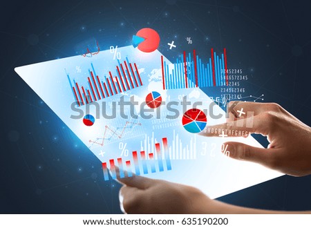 Young female hand holding a tablet with red and blue charts