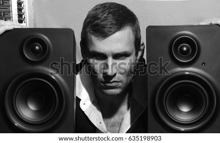 Black and white photo of a man with musical speakers