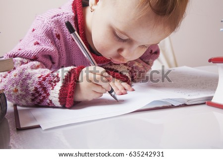Little beautiful girl writing in her book