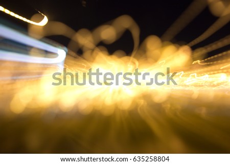 Defocused and motion blurred night scene with traffic lights