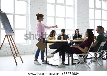 Professional female coach speaking during training seminar explaining new information to increase students knowledge, skilled leader of working crew discussing ideas for new startup project in office Royalty-Free Stock Photo #635274689