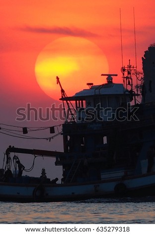 Fishing boat sailing through the sunset.