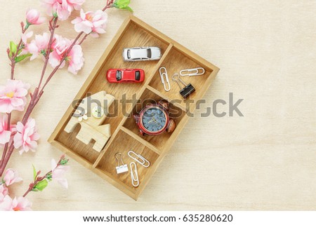Top view business concept. Wood house  also car and clock on wooden shelf.The beautiful pink flower on wood background with copy space.