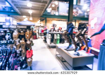 Blurred interior of sports and fitness clothing store in America. Activewear shop, famous brand worldwide of athletic shoes, gear and apparel with mannequins. Healthy lifestyle concept. Vintage tone.