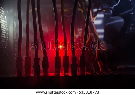 Network switch and ethernet cables, symbol of global communications. Colored network cables on dark background with lights and smoke. Selective focus. Network internet concept background