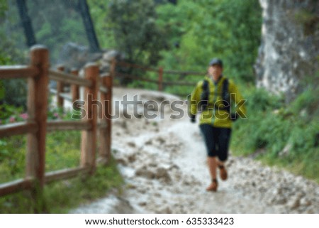 Picture blurred for background abstract and can be illustration Blurred background athletes running around the muddy track during the Trail Marathon