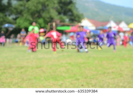 blurred picture of kid playing football at school football field   