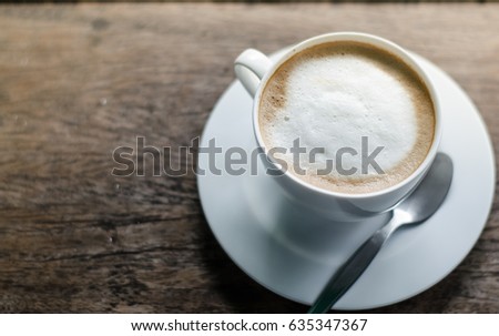 A cup of coffee in a white cup on wooden background Royalty-Free Stock Photo #635347367