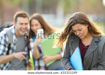 Bullying victim being video recorded on a smartphone by classmates in the street with a unfocused background Royalty-Free Stock Photo #635351249