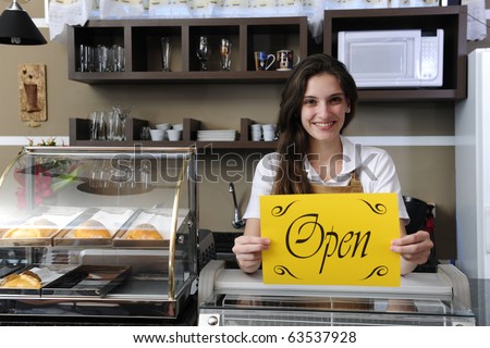 Small business: Happy owner or waitress of a cafe showing open sign