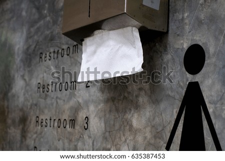  toilet sign on cement wall with  Box Covers and white Tissue on the wall look so clean 
